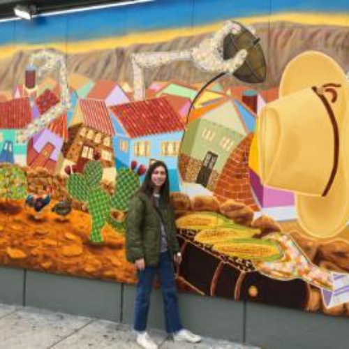 Photo of Austin Nelson in front of a colorful mural
